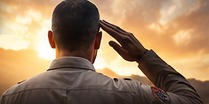A person saluting at sunrise, symbolizing a transition from service.