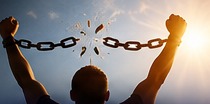 A person raising their arms as a chain breaks, symbolizing mental freedom.